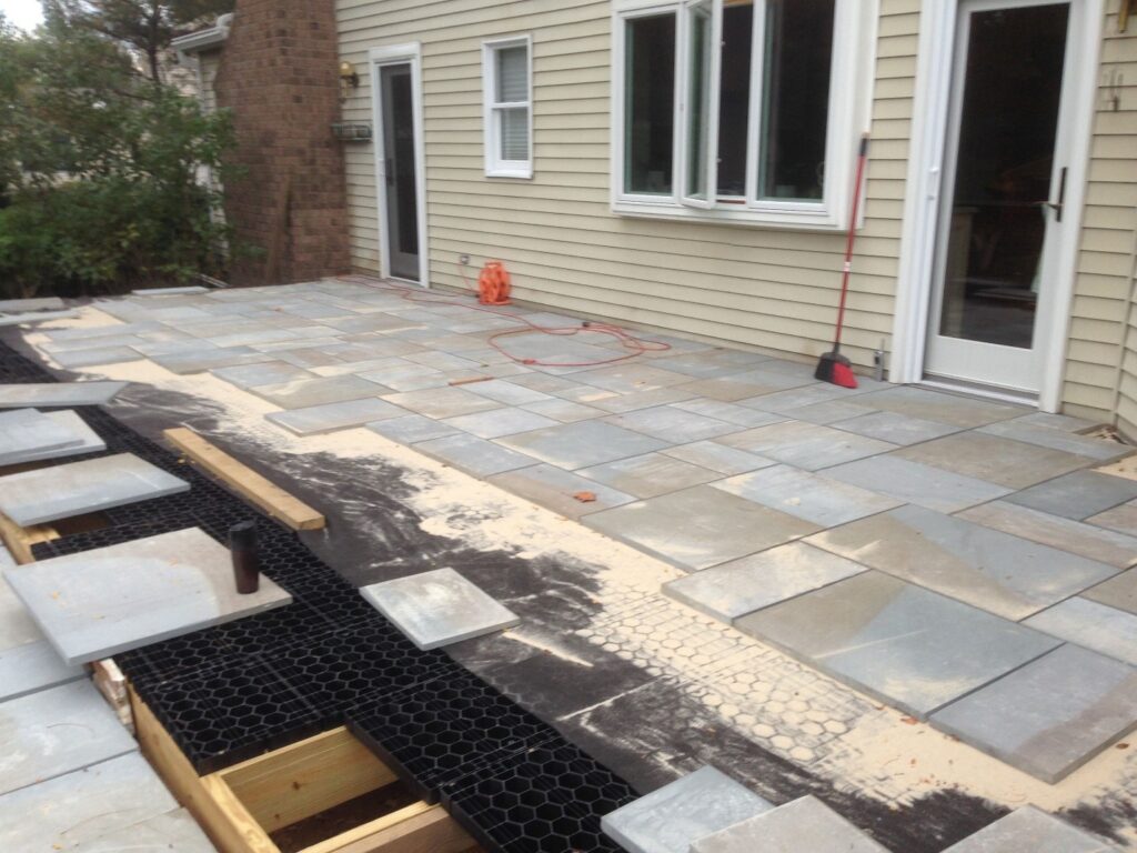 in progress deck build with Stonedeks silcagrate as underlayment for a concrete paver deck.